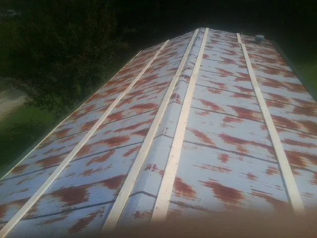 Rusted metal roof panels with new wood purlins before replacement — Storm Damage Roof Repair in Baskerville by Roofing Brothers