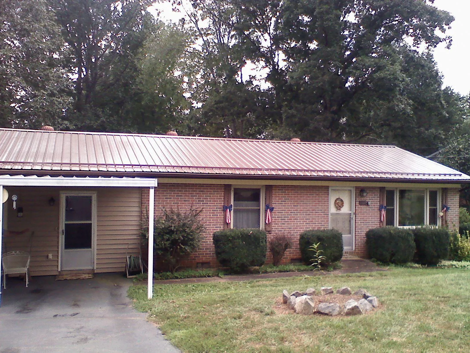 Bronze metal roof and carport on a brick ranch home — Roof Repair work by our crew in Baskerville